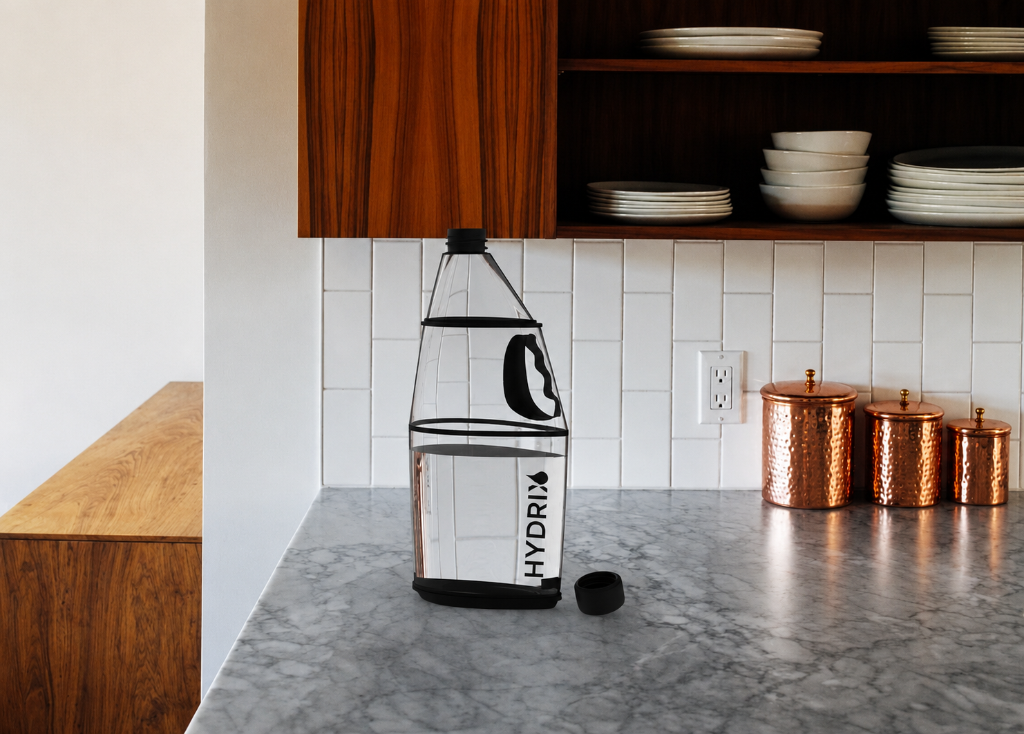 Hydrix bottle rendered on a marble kitchen counter with copper canisters in the background.