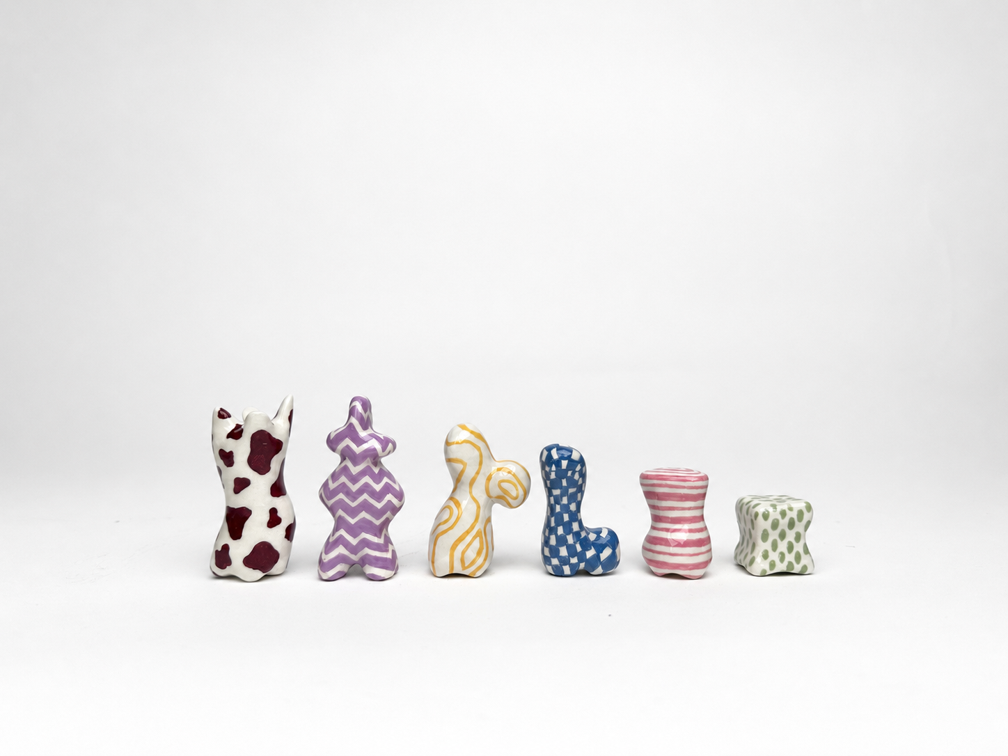 One example of each of the six chess piece types arranged in a single row, showing different colours and painted patterns.